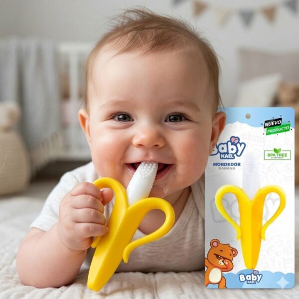 Bebé sonriente usando el mordedor de banana Baby Kael de silicona amarilla